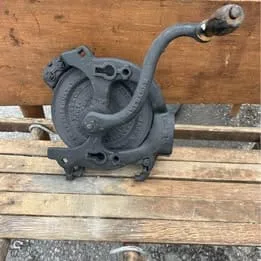 Heavy-duty antique cast iron corn sheller with a rustic, industrial farm tool design.