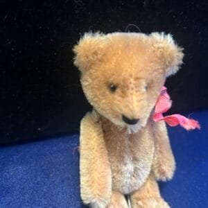 Vintage 5-inch Schuco mohair bear with glass eyes and a rare nodding mechanism.