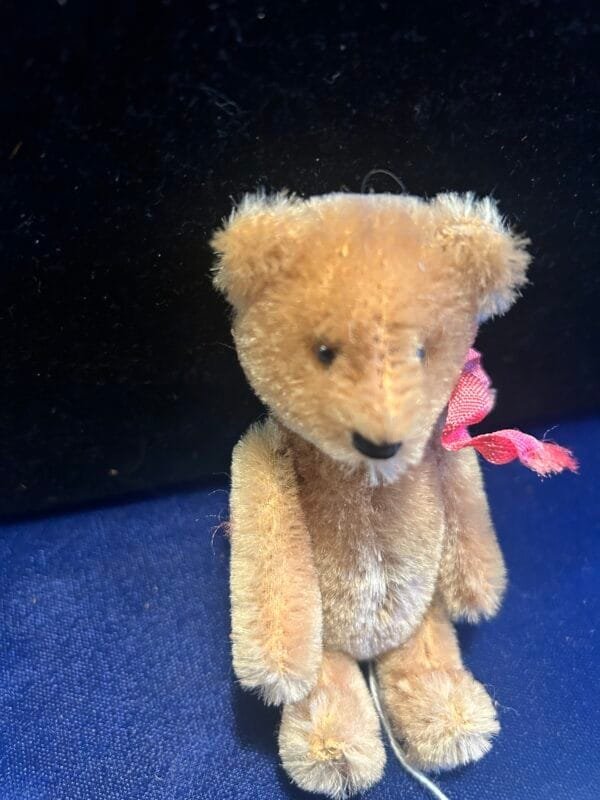 Vintage 5-inch Schuco mohair bear with glass eyes and a rare nodding mechanism.